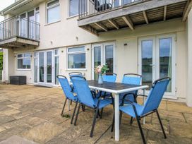 An outdoor patio with a table and chairs at Quay Sands, Hope Cove