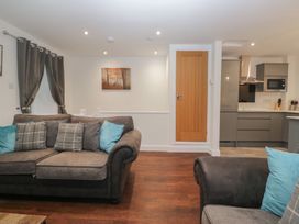 A living room with a sofa and kitchen area at 6 Hallin Fell in Penrith