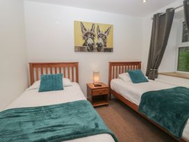 A bedroom with two beds and a painting at 6 Hallin Fell in Penrith