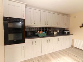 A kitchen with appliances and cabinets at Macmathuna in Kilrush, County Clare