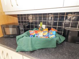 A kitchen with a bottle of wine and snacks on a countertop at Macmathuna, Kilrush, County Clare