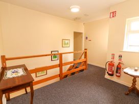 A hallway with a staircase and fire extinguishers at Macmathuna in Kilrush, County Clare