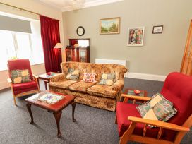 A living room with a sofa and armchairs at Macmathuna in Kilrush, County Clare