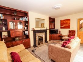 A living room with a fireplace and bookshelf at Macmathuna in Kilrush, County Clare