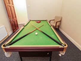A game room with a pool table and cues at Macmathuna Kilrush, County Clare