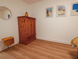 A bedroom with a wardrobe and a mirror at Creek Lodge in Chacewater