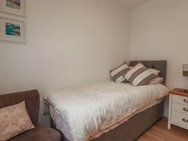 A bedroom with a bed and chair at Creek Lodge in Chacewater