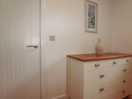 A dressing table with a vase and wall art at Creek Lodge in Chacewater