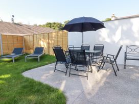 A garden with dining set and sun loungers at Creek Lodge in Chacewater