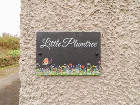A sign that reads 'Little Plumtree' with a bird and flowers at Little Plum Tree in Milnthorpe