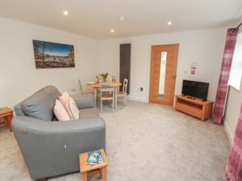 A living room with a sofa and dining table at Little Plum Tree in Milnthorpe