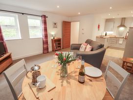 A living room with a dining table and sofa at Little Plum Tree in Milnthorpe