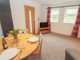 A dining room with a table and television at Little Plum Tree in Milnthorpe