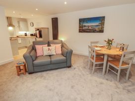 A living room with a sofa and dining table at Little Plum Tree in Milnthorpe