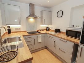 A kitchen with cabinets and appliances at Little Plum Tree in Milnthorpe