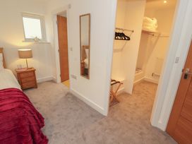 A bedroom with a bed, lamp, and closet at Little Plum Tree in Milnthorpe