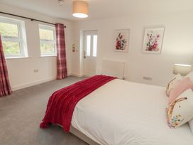 A bedroom with a bed and windows at Little Plum Tree in Milnthorpe