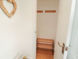 A closet with wooden shelving and hooks at Little Plum Tree in Milnthorpe
