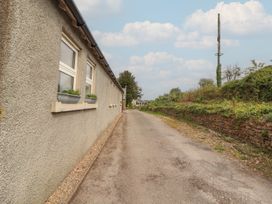 A pathway alongside a building with windows at Little Plumtree in Milnthorpe