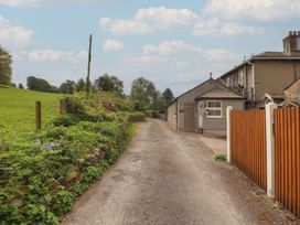 A road beside a building with a fence and garden at Little Plumtree in Milnthorpe