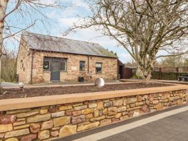 A house with stone walls and a garden in Blue Heron Lodge Kirkby Stephen
