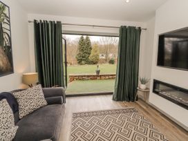 A living room with a sofa and television at Blue heron lodge in Kirkby Stephen