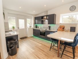 A kitchen with modern appliances and a table at Blue heron lodge in Kirkby Stephen