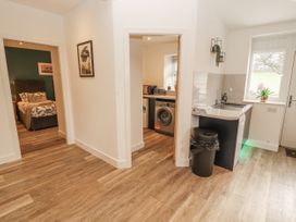 A hallway with a washing machine and access to a bedroom at Blue heron lodge in Kirkby Stephen