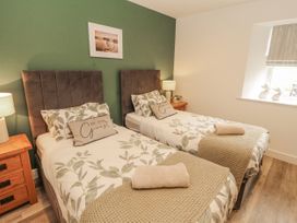 A bedroom with twin beds and a bedside table at Blue heron lodge in Kirkby Stephen
