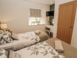 A bedroom with two beds and a television at Blue heron lodge in Kirkby Stephen