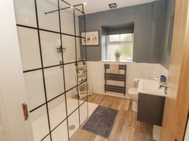 A bathroom with shower, toilet, sink, and towel rack at Blue heron lodge in Kirkby Stephen