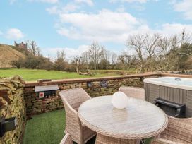 An outdoor area with a table and chairs next to a hot tub at Blue heron lodge in Kirkby Stephen