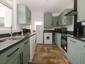 A kitchen with cabinets and appliances at Gwynfa in Old Colwyn