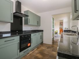 A kitchen with cabinets, oven, and sink at Gwynfa in Old Colwyn