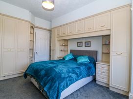 A bedroom with a bed and wardrobe at Gwynfa in Old Colwyn