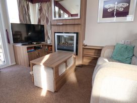 A living room with a television and fireplace at Caravan B14 Beechrise Filey