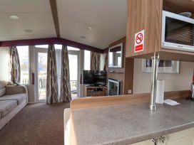A living room with a television and sofa at Caravan B14 Beechrise in Filey