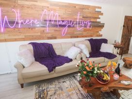 A living room with a sofa and coffee table featuring fruits and flowers at Piskies Magic Home