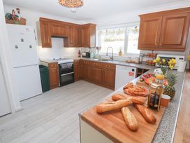 A kitchen with wooden cabinets and various food items at Piskies Magic Home
