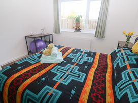 A bedroom with a bed and decorative blanket at Piskies Magic Home