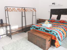 A bedroom with a bed and clothes rack at Piskies Magic Home 