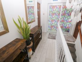 A hallway with console tables and a glass door at Piskies Magic Home