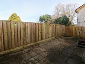 A garden area with a wooden fence and paving stones at Piskies Magic Home 
