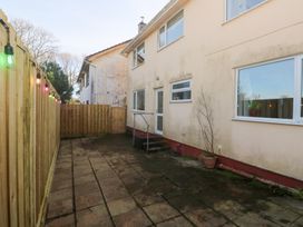 A garden with a patio and steps leading to a door at Piskies Magic Home 