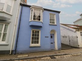 A blue house with a gate at 1 Alpha Cottages in Tenby