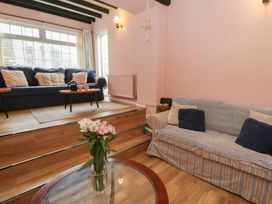 A living room with two sofas and a flower vase at 1 Alpha Cottages in Tenby