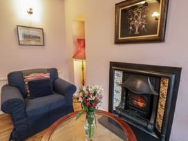 A living room with an armchair and a fireplace at 1 Alpha Cottages in Tenby