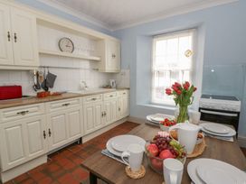 A kitchen with a table set for dining at 1 Alpha Cottages in Tenby