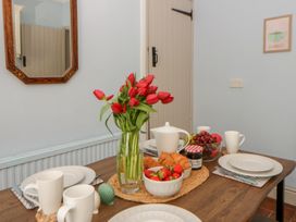A dining room with a table set for breakfast at 1 Alpha Cottages in Tenby