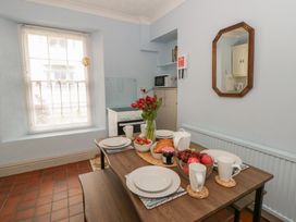 A kitchen with a dining table set for breakfast at 1 Alpha Cottages in Tenby